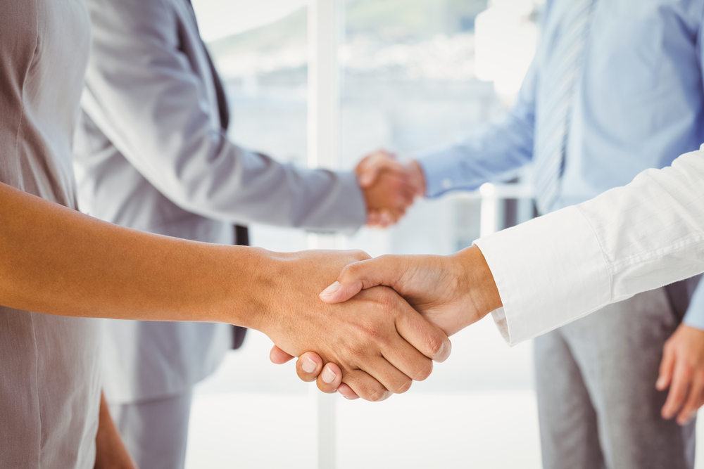 Two fellow employees shaking hands at work